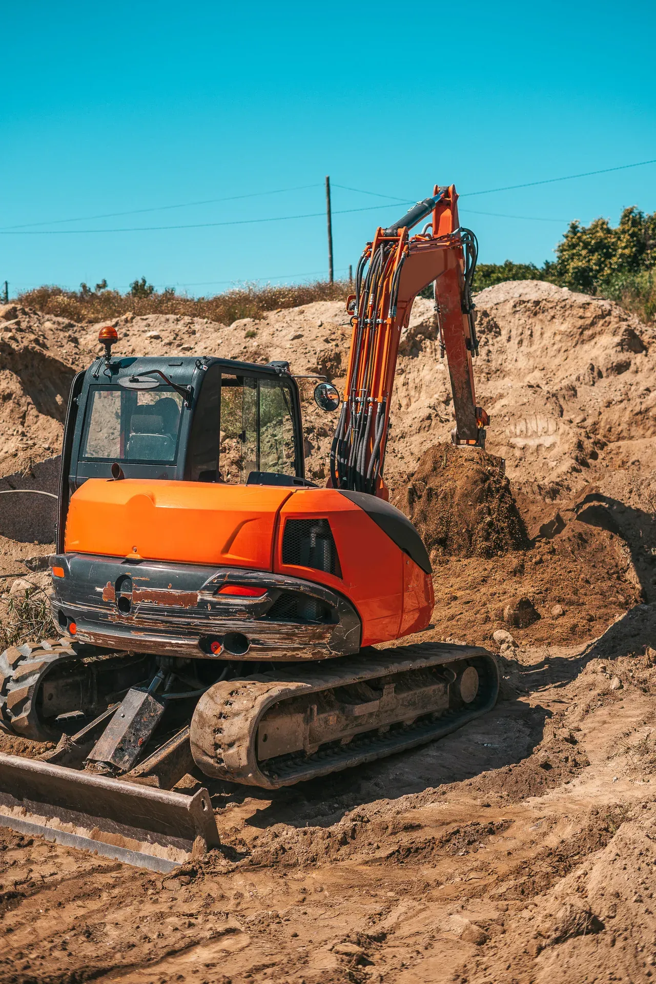 Bagger seitlich auf einer Baustelle, Hochformat